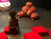 enfant assis face à un bonhomme