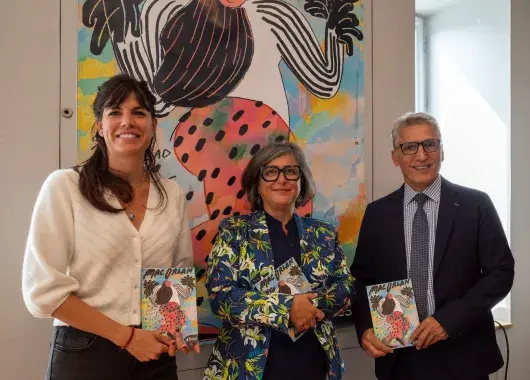 Trois personnes tiennent des affiches.